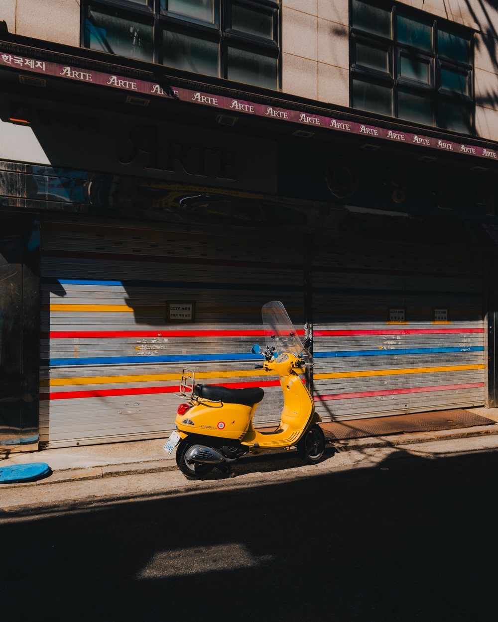 Yellow Vespa, striped shutter
